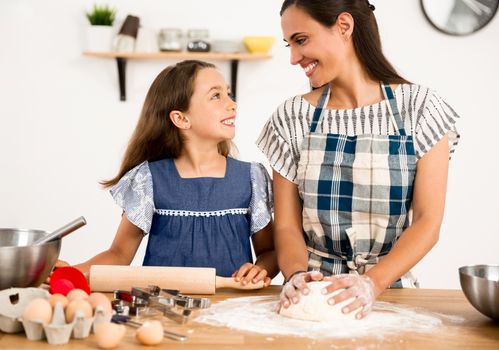 Shot of a mother and daughter having fun in the kitchen and learning to make a cake