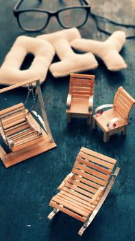 Amazing miniature handmade product for interior design, mini furniture make from wood stick on wooden background, small swing, chair so cute and diy knitted alphabet 