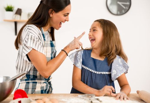 Shot of a mother and daughter having fun in the kitchen and learning to make a cake