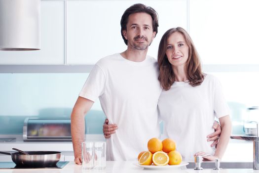 Couple with orange juice in the kitchen