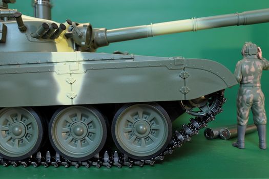 commander in overalls and a helmet standing at battle tank