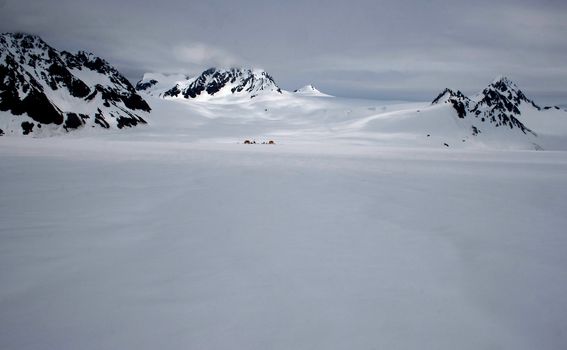 An expansive view of a Glacier in Seward, Alaska with a camp set up in the distance. 