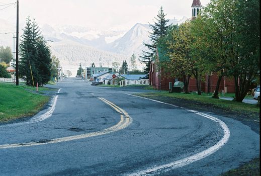 A bend in the road with mountains in the background in the city of Seward, Alaska. 
