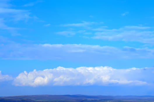 Sea against a blue sky with white clouds