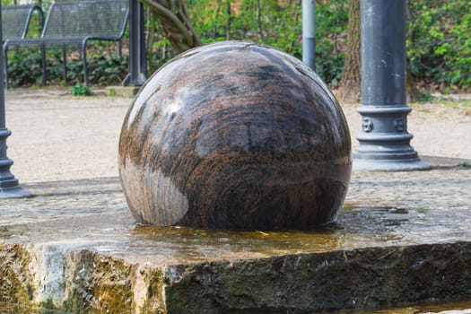 Large floating ball dark granite with decorative elements as Fountain