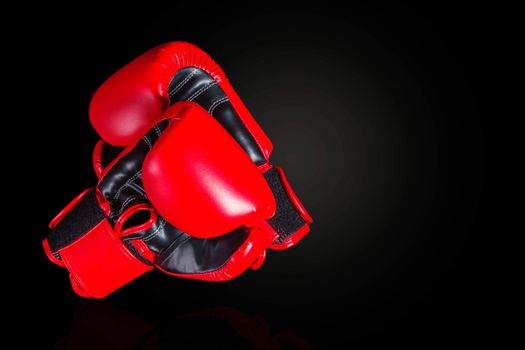 Red boxing gloves on a black background.