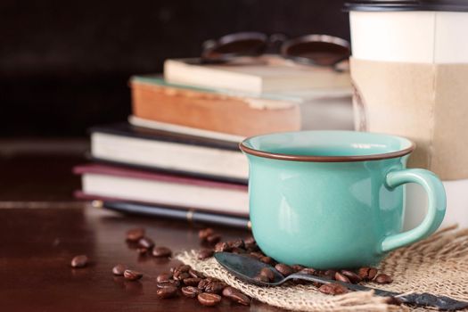 Hot of coffee cup with books on the desk.