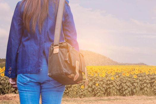 Female travelers trip with the sunflower field.