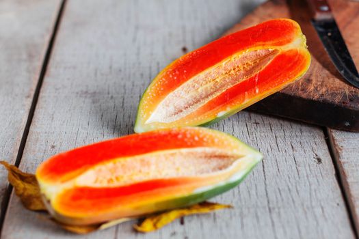 Ripe papaya of half on the old wooden table.