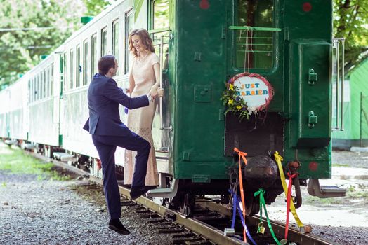 Just married happy couple on the ladder last wagon in Lviv, Ukraine