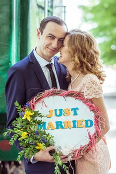 Close up portrait of loving couple. Man and woman standing near the wagon with a sign just married in Lviv Ukraine