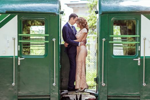 Just married couple standing at the junction between by wagons in Lviv, Ukraine