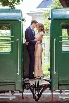 Just married couple standing at the junction between by wagons in Lviv, Ukraine