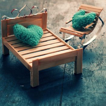 Two hearts be together, illustration for couple in love, take care and loving, green heart on handmade mini furniture as chair, swing, bed on wood background