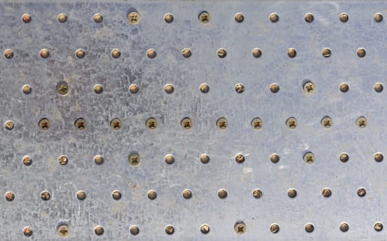 Texture of the metal plate with bolts and holes.