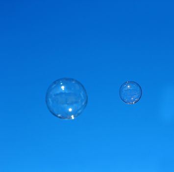 Soap bubble flying against the blue sky.