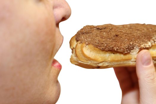 Close up of a young woman eating a cake eclair over white background.