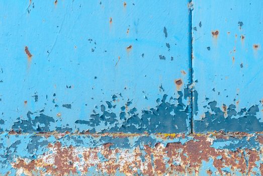 fragment of an iron surface is covered with blue color paint, which has long been under the influence of different climatic conditions