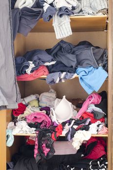 Pile of carelessly scattered clothes in wardrobe