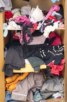 Pile of carelessly scattered clothes in wardrobe