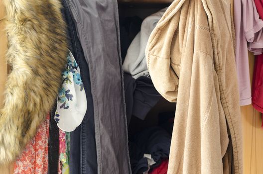 Pile of carelessly scattered clothes in wardrobe