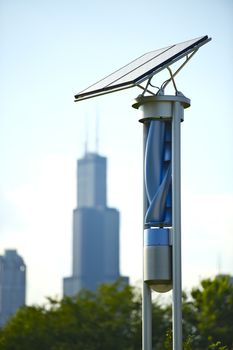 Small Creative Solar and Wind Energy Generator. Chicago Downtown in the Background. Small Solar Panel on the Top and Spiral Wind Generator Below. Alternative Energy Sources in Chicago, Illinois, USA.