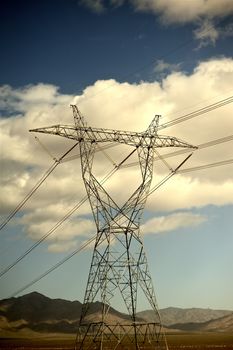 High Voltage Power Lines in Nevada Deserts, USA. Cloudy Summer Sky. Vertical Photo