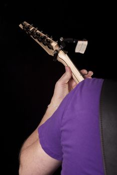Guitar Play. Vertical Photo of the Guitar Player. His Shoulder, Hand and the Guitar. Solid Black Background.