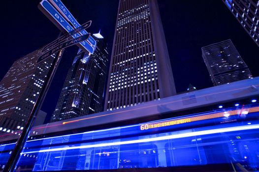 Metropolitan Bus in Motion. Night Bus Line. Chicago by Night. Long Exposure Wide Angle Bus in Motion with Skyscrapers in the Background. Horizontal Photography