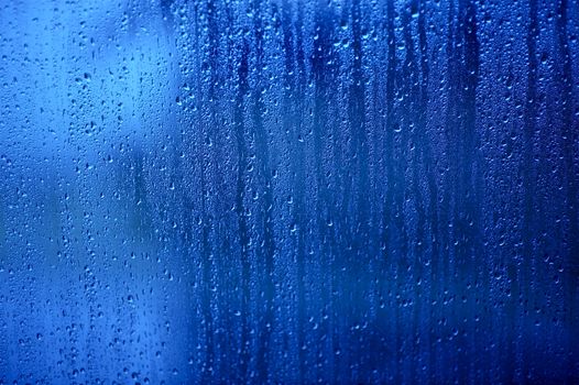 Wet Glass. Water Drops on the Blue Glass - Background, Texture