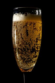 Sparkling Champagne Glass. Elegant Glass - Black Background. Vertical Photo.