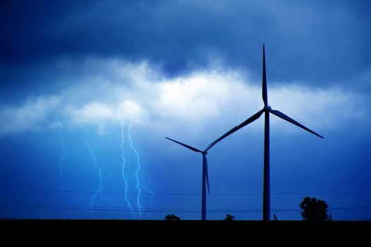 Wind Turbines and Summer Lightning Storm. Technology and Nature Theme. Bluish Colors.