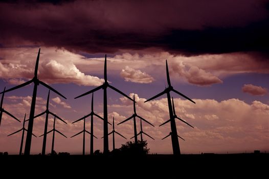 Wind Turbines Farm After Dark. Pinky Stormy Sky and Wind Turbines.