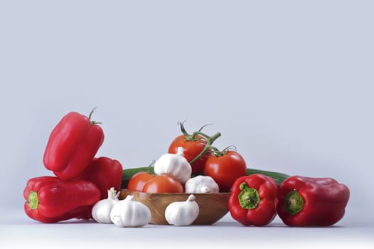Fresh Vegetables on Solid Background. Tomatoes, Red Paprikas, Garlic and Cucumber. Vegetables Photo Collection.