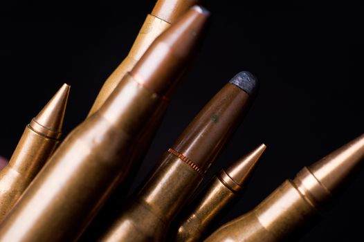 Golden Rifle Bullets on Black Background. Closeup-Macro Photography