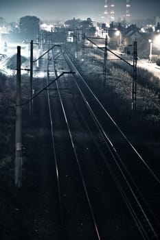 Railroad Tracks Somewhere in Poland, Europe. Railroads in Night Time Photography. Vertical Railroads Photo.