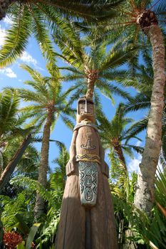 African Wood Sculpture Between Palm Trees. African Theme