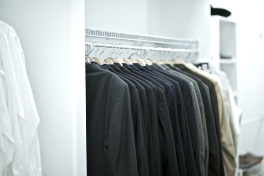 Black Brand Name Suits in Large Closet Area. Luxury Living