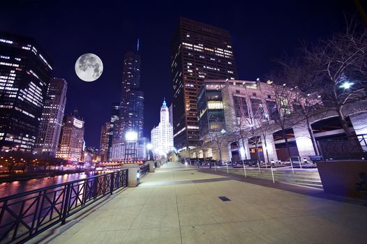 Chicago Famous Riverwalk - Chicago Riverwalk at Night. Beautiful Colorful Wide Angle Photography. Large Moon on the Sky. Chicago, Illinois, USA.