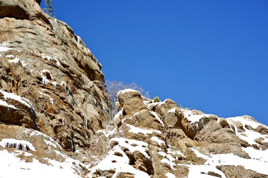 Winter in Rocky Mountains, Colorado USA. Rocks in Snow. Clear Blue Sky
