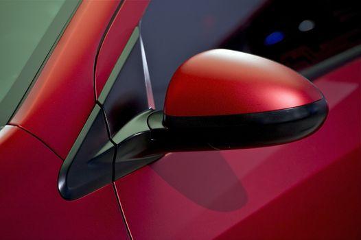 Car Driver Mirror. Red Modern Car - Outside Car Side Mirror Closeup