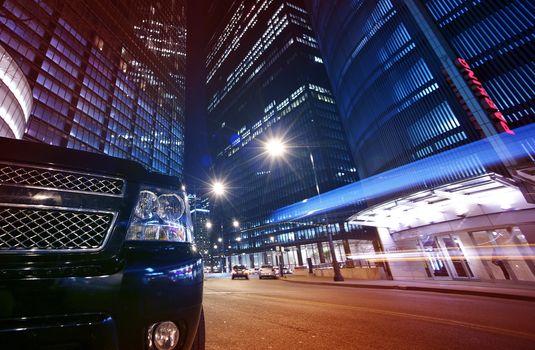 Night Life Chicago. Long Exposure Street Traffic Downtown Chicago with Front of Black SUV. Wide Angle Photography