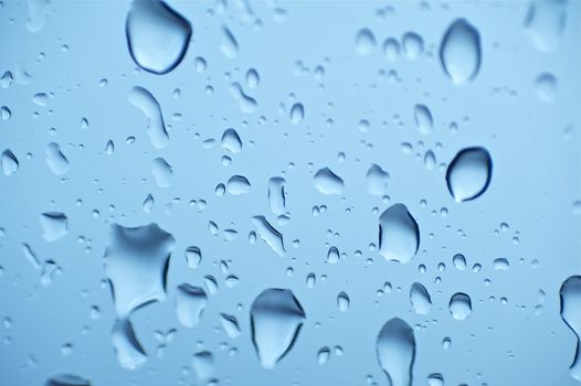 The Rain on the Blue Glass. Water Drops on Glass