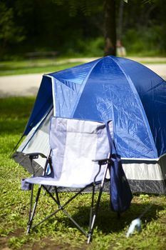 Camping. Small Blue Iglo Tent and Camping Seat. Outdoor Fun on the Campground. Vertical Photography. Small Summer Camping.