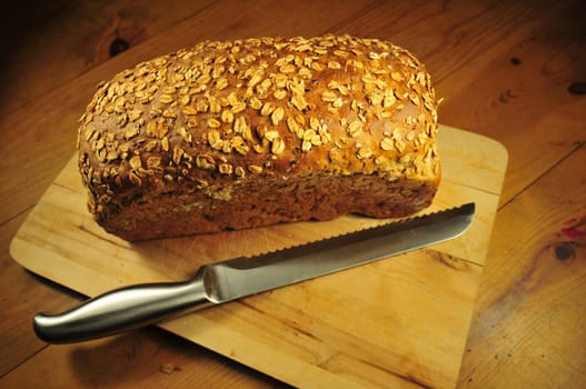 Fresh Homemade Wholegrain Bread on the Wood Table. Metal Bread Knife