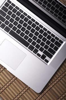 Modern Laptop Computer - Top View. Silver Metallic Body and Black Keyboard. Internet - Mobility Theme. Vertical Photo.
