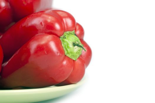 Red Paprika Fruits on Light Green Plates. Red Paprika Isolated on White Background. Horizontal Closeup Photo.