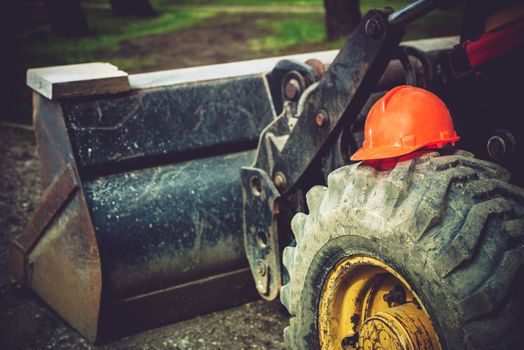 Construction Safety Helmet on Bulldozer Tire. Heavy Equipment Operation Safety.