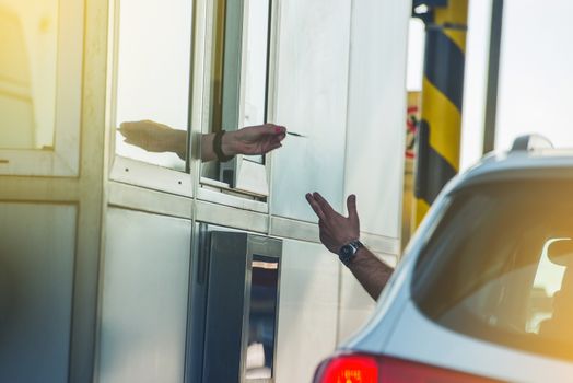 Paying Highway Toll. Men in the Car Paying the Toll. Highway Systems.