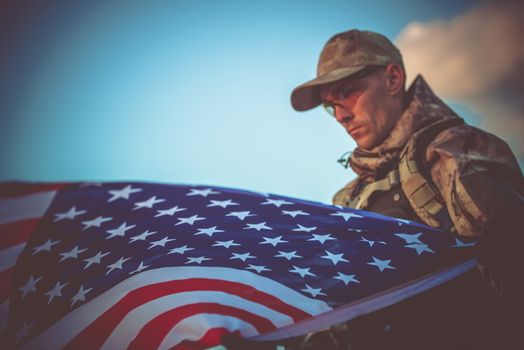 Young Army Veteran with American Flag Closeup Photo. Army Trooper with USA Flag.
